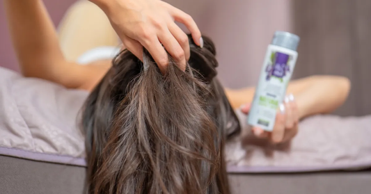 Woman running her fingers through her hair because of an itchy scalp without dandruff, with Organic Clary Sage Water Hydrolina beside her
